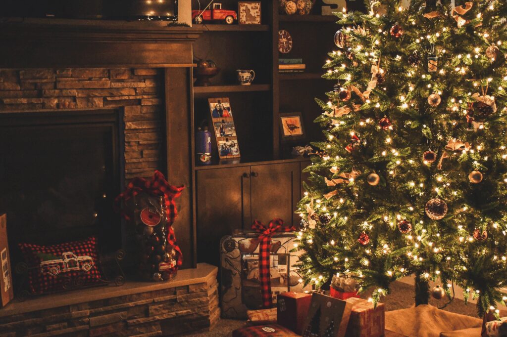Beautifully decorated living room featuring a glowing Christmas tree and fireplace, highlighting holiday home appeal.