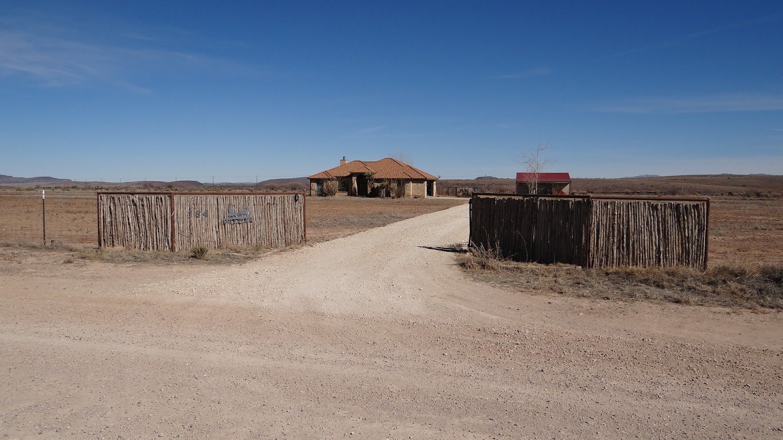 Windmill and steel water storage tank beside a stock tank on a Far West Texas ranch